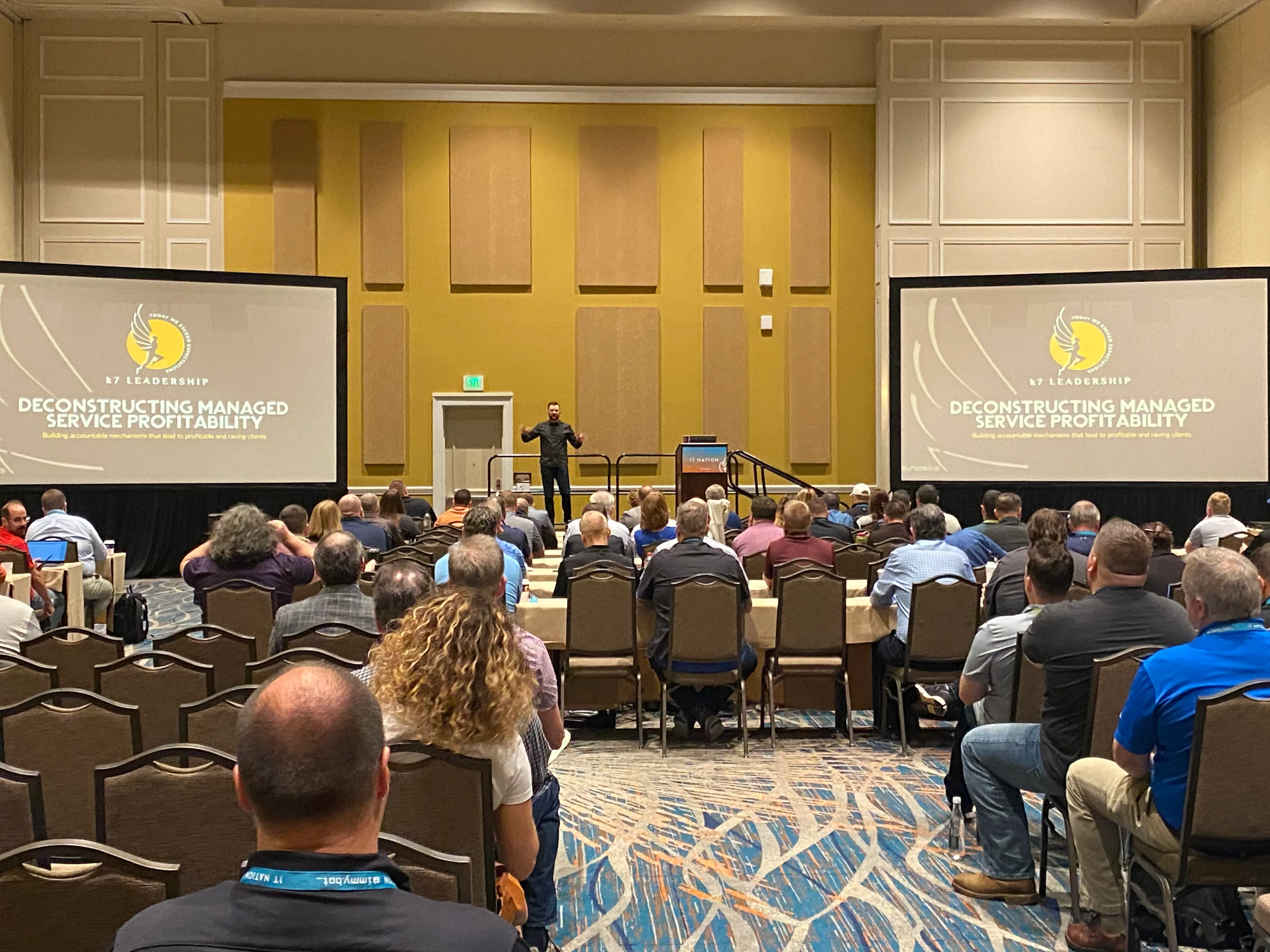 Kyle Christensen speaking on stage at an MSP industry event